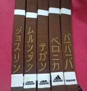 Sensei Zoe puts calligraphy on all the belts